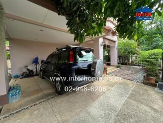 Car parked in a driveway beside a house with a garden