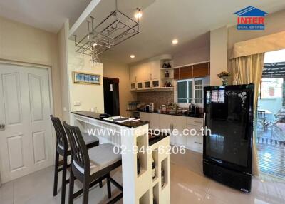 Modern kitchen with breakfast bar and black refrigerator