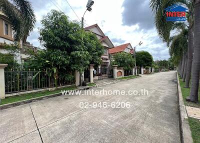 Street view of residential buildings with lush greenery