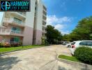 Exterior view of the apartment building with nearby parking area