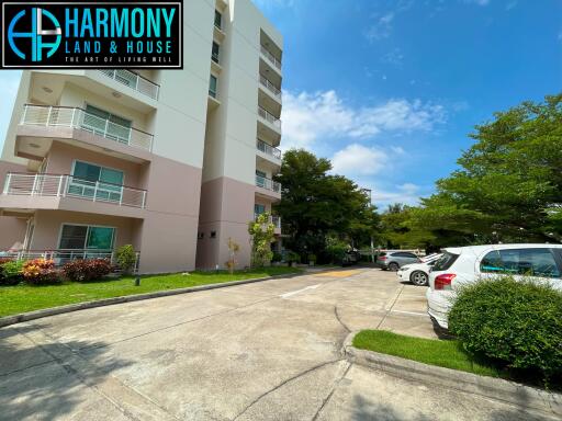 Exterior view of the apartment building with nearby parking area