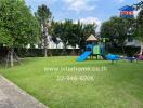 Children's playground in outdoor area with green lawn and trees