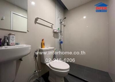 Modern bathroom with toilet, sink, and shower