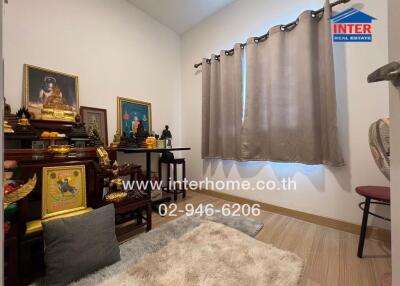 Small bedroom with religious decorations and carpeted floor