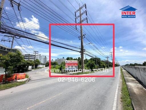 Street view with power lines and real estate sign