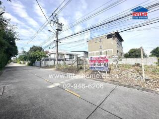 Street view with a vacant lot and nearby buildings