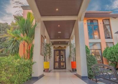 Elegant house entrance with tall windows and lush green plants