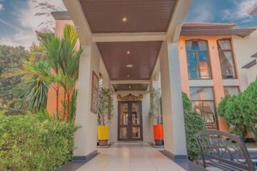 Elegant house entrance with tall windows and lush green plants