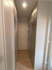 Narrow walk-in closet with built-in shelving