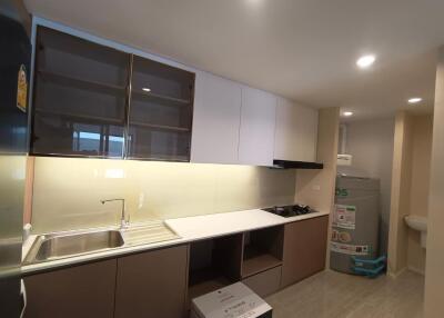 Modern kitchen with sink, stove, and storage cabinets.