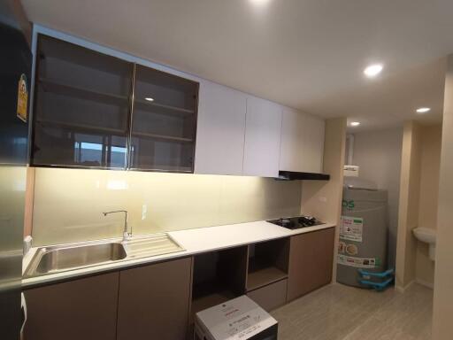 Modern kitchen with sink, stove, and storage cabinets.