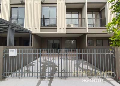 Exterior view of a modern multi-story building with a gated driveway