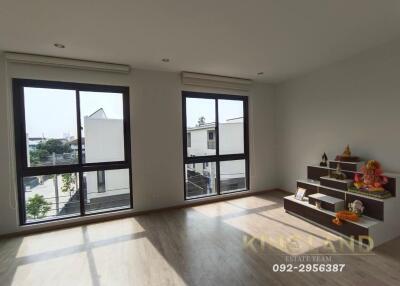 Spacious living room with large windows and wooden floor