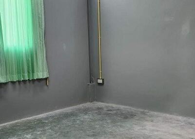 Empty room with concrete floor and green curtains