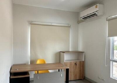 Small home office with desk, chair, air conditioner, and wooden cabinet