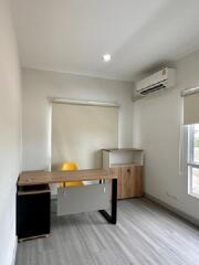 Small home office with desk, chair, air conditioner, and wooden cabinet