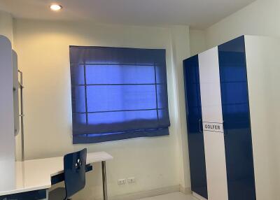 Bedroom with blue blinds, blue and white wardrobe, and study desk