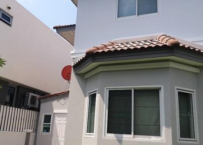 Exterior of a modern two-story house with a red satellite dish