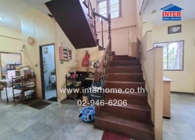 Interior staircase area with adjacent storage and kitchen