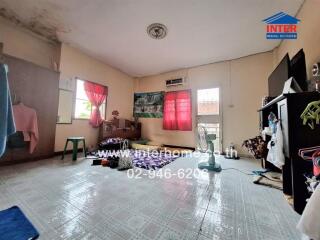 Spacious bedroom with window, air conditioner, and various furniture