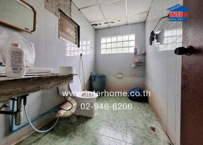 Bathroom with tiled walls and floors, window, and basic fixtures