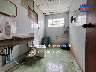 Bathroom with tiled walls and floors, window, and basic fixtures