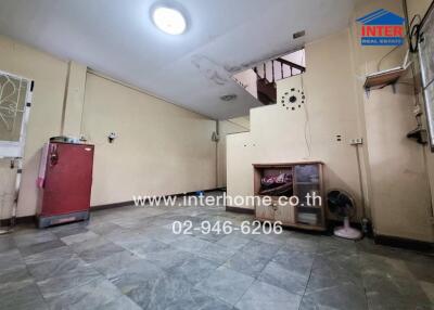 Spacious main living area with tiled flooring and stair access.