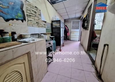 Simple kitchen setup with basic essentials and a passage towards the back door