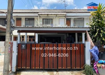 Two-story house facade with fenced yard