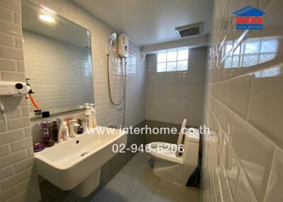 Modern bathroom with sink, mirror, toilet, and shower