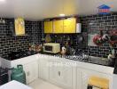 Modern kitchen with black tile backsplash and white cabinets