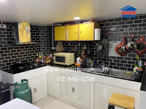 Modern kitchen with black tile backsplash and white cabinets