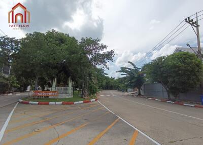 View of the entrance to a residential area with trees and street