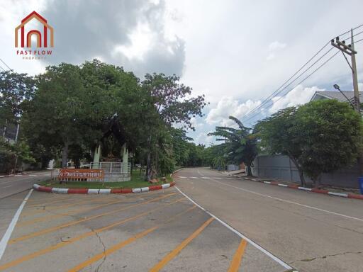 View of the entrance to a residential area with trees and street