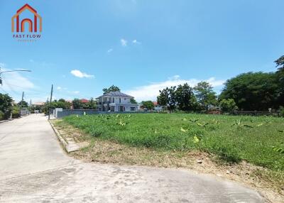 Exterior view of a property with a surrounding grassy area and nearby house