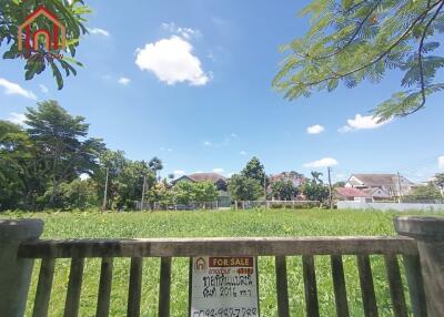 Vacant land for sale with greenery and houses in the background