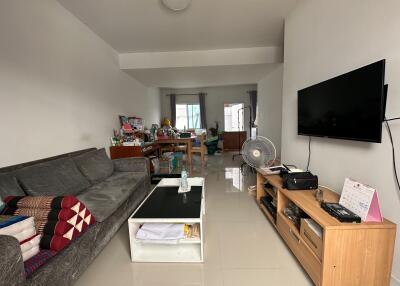 Living room with a sofa, coffee table, wall-mounted TV, and other furniture.