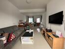 Living room with a sofa, coffee table, wall-mounted TV, and other furniture.