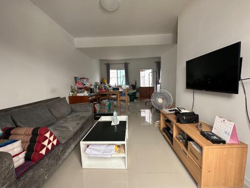 Living room with a sofa, coffee table, wall-mounted TV, and other furniture.