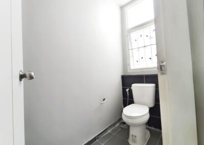 Simple white bathroom featuring a toilet and window.