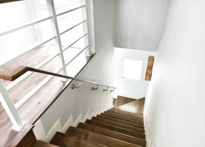 Well-lit staircase with wooden steps and metal railings