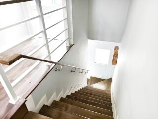 Well-lit staircase with wooden steps and metal railings