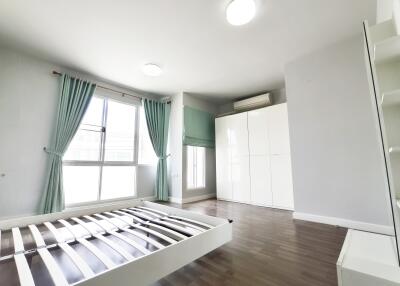 Spacious bedroom with large windows, wooden floor, and ample storage