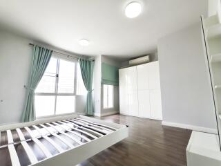 Spacious bedroom with large windows, wooden floor, and ample storage