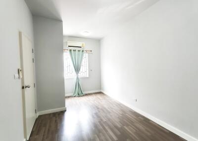 Bright empty bedroom with window and air conditioning