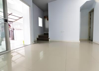 Spacious living area with tiled flooring and access to staircase