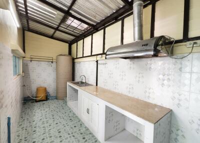 Clean, functional kitchen with tiled walls and modern range hood