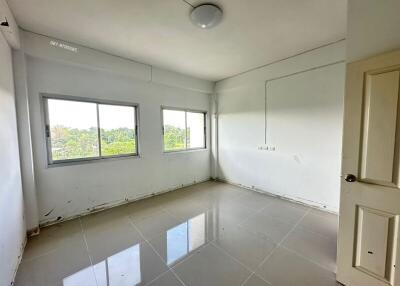 Empty room with tiled floor and large windows