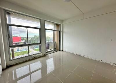 Spacious living room with large windows and tiled floors