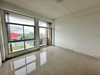 Spacious living room with large windows and tiled floors